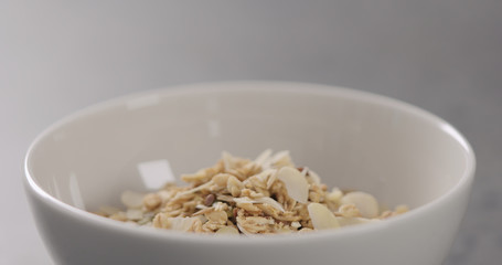 closeup granola with almond flakes in white bowl