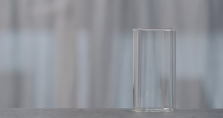 empty glass on concrete countertop with window on background