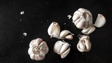 Beautiful textured garlic on a black table. Food concept. View from above