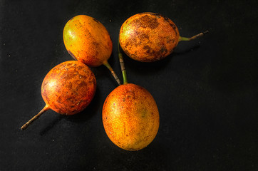 Fresh ripe orange passion fruit on a black table. Food concept