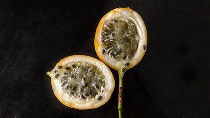 Fresh orange open passion fruit on a black background. Healthy food. Ripe fruit