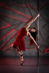 Beautiful girl dancing on the pole at studio