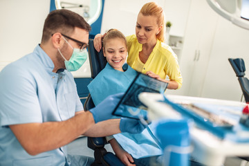 Mother and daughter at visit in the dentist office