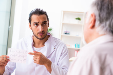 Old man visiting young male doctor cardiologist