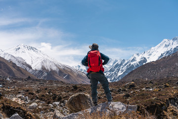 Fototapeta premium A trekker with backpack trekking in Langtang valley, travelling in Himalya mountain range in Nepal
