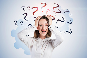 Shocked young woman, question marks and gears