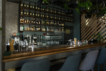 Empty wooden bar counter with bottles of alcohol drinks