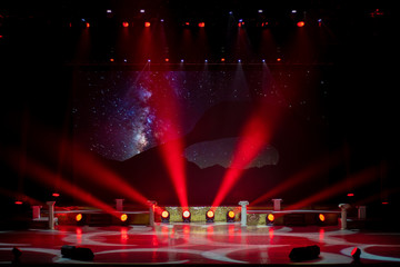 An empty stage of the theater, lit by spotlights and smoke before the performance