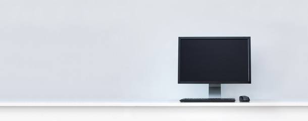 Clean white desk with computer and copy space.