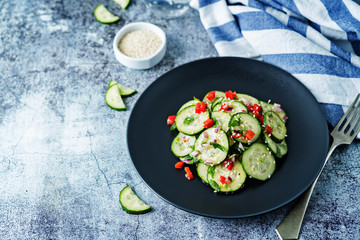 Cucumber spice salad with red onion, red pepper and sesame seeds