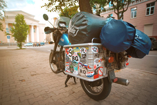 Minsk, Belarus. Jul 2019. Vintage MZ ETZ 301 - brand East German mortorcycle with metal suitcase covered with stickers from different countries. Motorcycle with travel baggage parked on the street