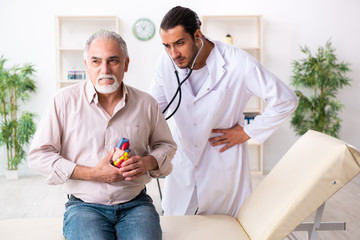Old man visiting young male doctor cardiologist