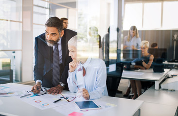 Portrait of happy business people discussing together in office