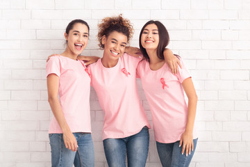 Happy Ladies In Breast Cancer T-Shirts Hugging Over White Background