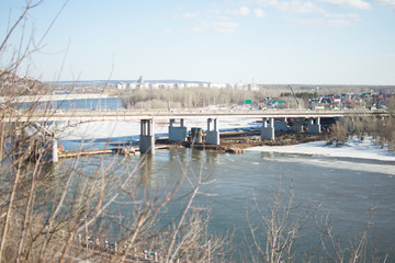 Fototapeta na wymiar Ufa city bridge cars houses construction spring river