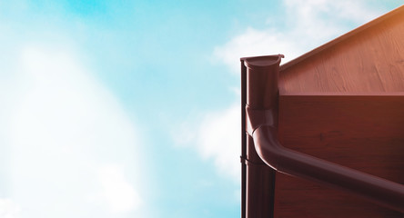 Modern roof gutter and drain pipe with copy space and blue sky for store banner or the production plant.
