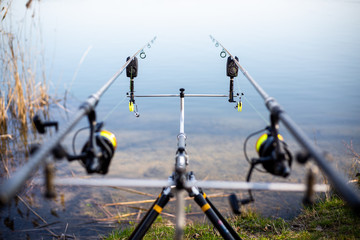 Close up of rack with fishing rods by the lake, fisherman waiting for freshwater fish, fishing background, angling sport