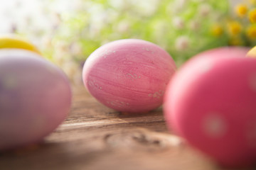 Colorful easter eggs with flowers on a old wooden surface