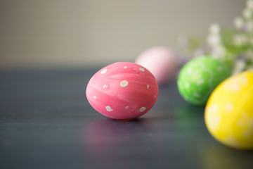 Colorful easter eggs with flowers on a gray wooden surface