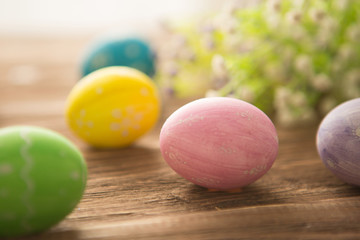 Fototapeta na wymiar Colorful easter eggs with flowers on a old wooden surface