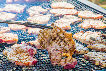 sausages and pork steaks on the large barbeque
