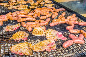 sausages and pork steaks on the large barbeque
