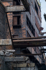 Fototapeta na wymiar Broken windows in a brick wall of an abandoned factory