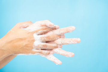 Close up of Asian women Cleaning hands with white soap bubbles on blue background. Hand washing demonstration for virus protection. Concepts of hygiene and prevention of covid 19