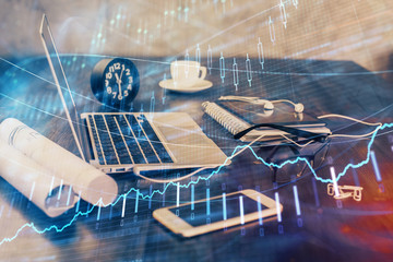 Forex market graph hologram and personal computer on background. Double exposure. Concept of investment.