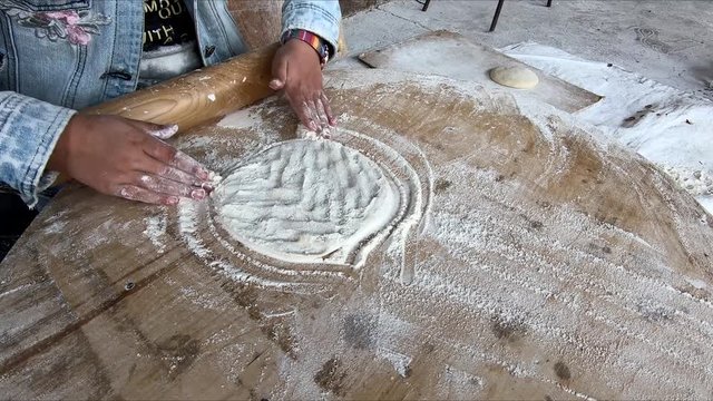 Cooking Armenian pita bread. Female hands. A woman rolls out the dough. Flour