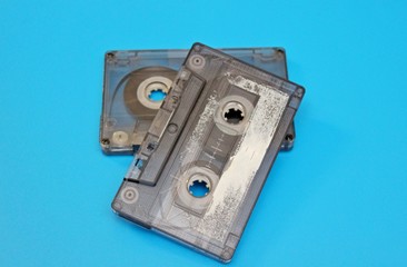 Old audio cassettes are located on a blue background