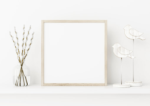 Square poster frame mockup. Spring interior decoration with willow branches and wooden birds on empty white wall background. 3D rendering, illustration.