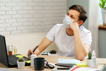 Sick man with medical protective mask on his face working in office. Coronavirus outbreak concept