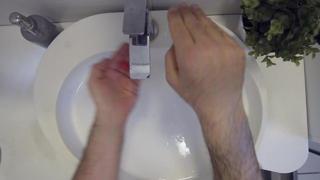 Lavaggio accurato delle mani nel lavandino di casa strofinando bene anche le dita