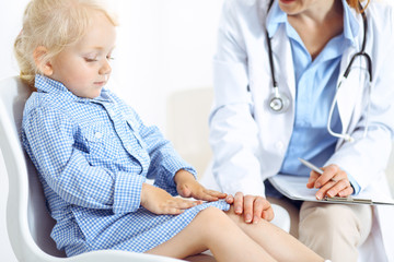 Happy smiling child patient at usual medical inspection. Doctor and patient in clinic. Medicine, healthcare concepts