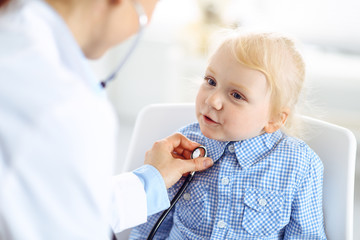 Happy smiling child patient at usual medical inspection. Doctor and patient in clinic. Medicine, healthcare concepts