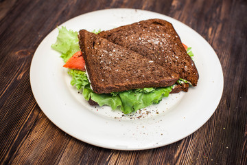 Two rye bread sandwiches with red fish and lettuce