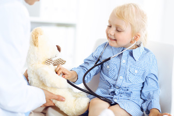 Happy smiling child patient at usual medical inspection. Doctor and patient in clinic. Medicine, healthcare concepts