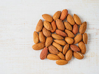 Almond nuts isolated on white wooden background.