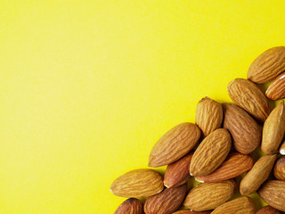 Almond nuts isolated on yellow background.