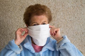 portrait of senior woman putting on medical mask. Generalized safety during coronavirus outbreak.