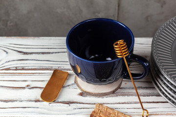 Still life photo of empty tea cup with honey spoon. Kitchen table close up
