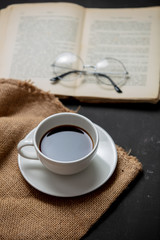 Cup of coffee and book with glasses