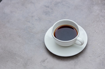 cup of black coffee on gray background