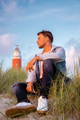 Texel lighthouse during sunset Netherlands Dutch Island Texel, couple visit the lighthouse , men...
