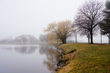 Fototapeta na wymiar Quiet community park covered in dense fog during cold winter to spring season 