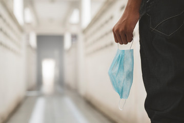 man holding a surgical mask outdoors. Concept of pandemic, virus outbreak and health care