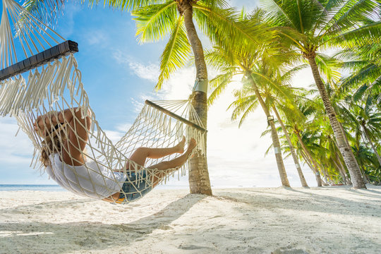 Woman relaxing on hammock on the beach. Travel and vacation concept. Banner edition.