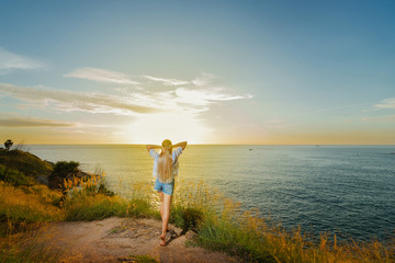 Woman enjoing sunset on cape. Phuket, Thailand.