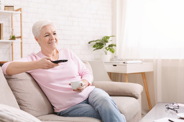 Senior lady enjoying tv shows at home, free space
